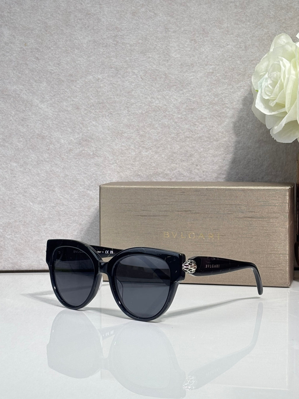Bvlgari round cat-eye sunglasses with black frame and dark yellow tinted lenses