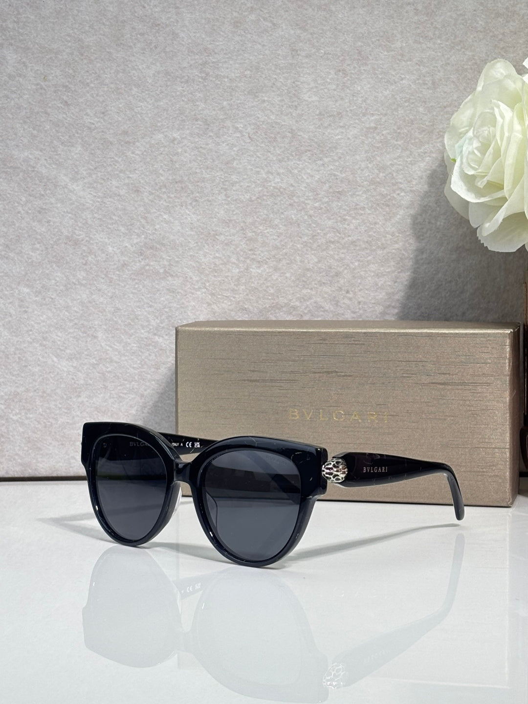 Bvlgari round cat-eye sunglasses with black frame and dark yellow tinted lenses