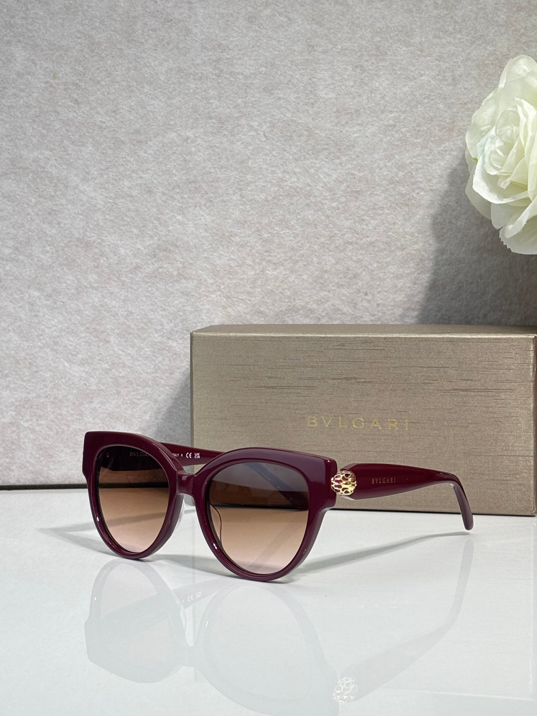 Bvlgari round cat-eye sunglasses with burgundy frame and dark red tinted lenses
