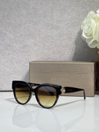 Bvlgari round cat-eye sunglasses with black frame and yellow-brown tinted lenses