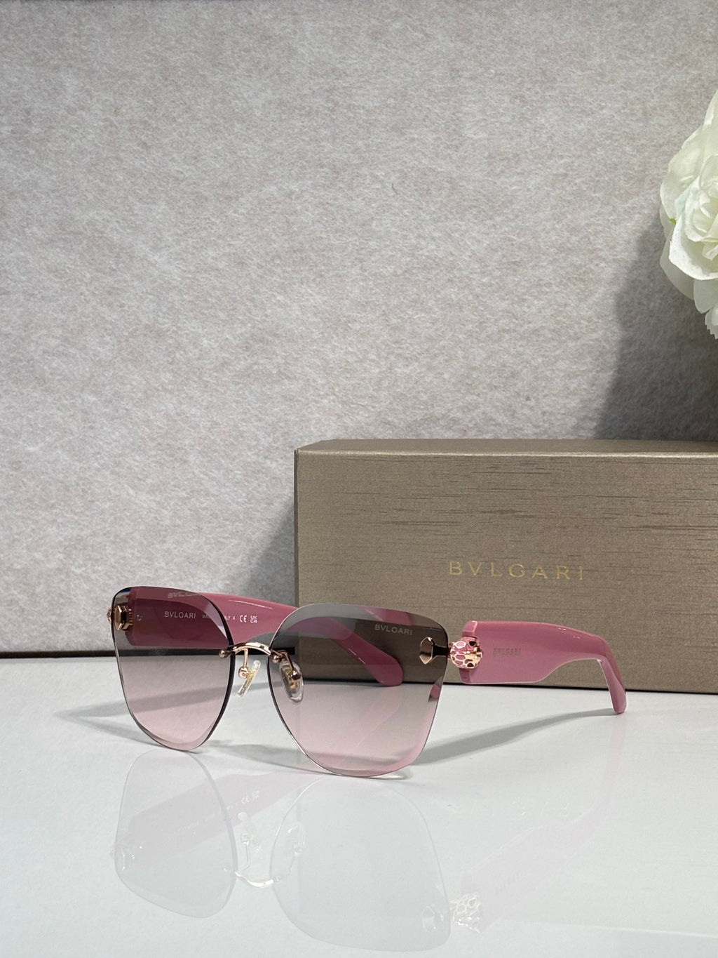 Bvlgari sunglasses with pink-tinted gradient lenses, burgundy frame and gold emblem