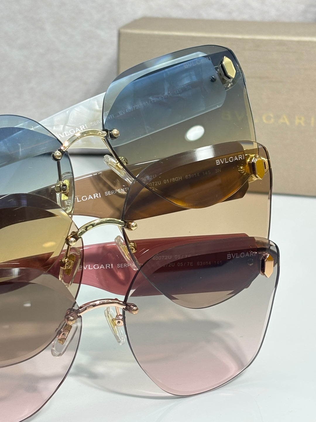 Sunglasses closeup with blue-tinted lenses and gold-tone hinge detail on frame