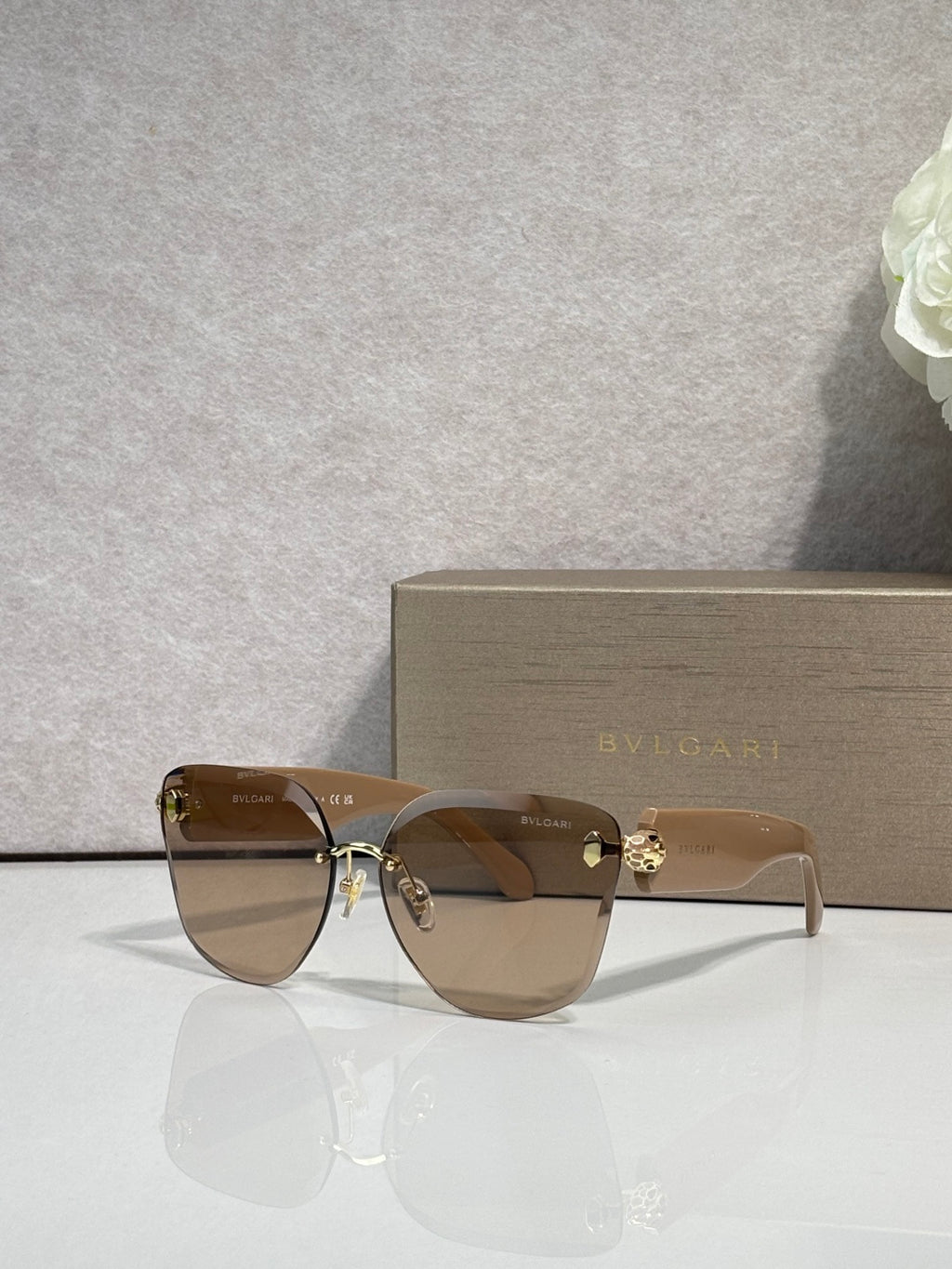 Bvlgari sunglasses with brown gradient lenses, tan frame and gold emblem bridge