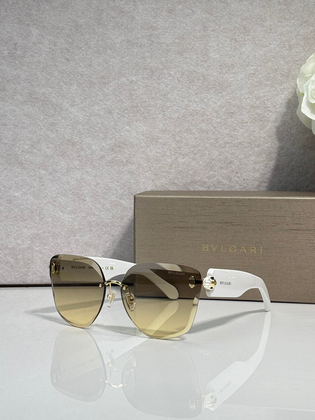Bvlgari sunglasses with olive gradient lenses, light frame and gold emblem bridge