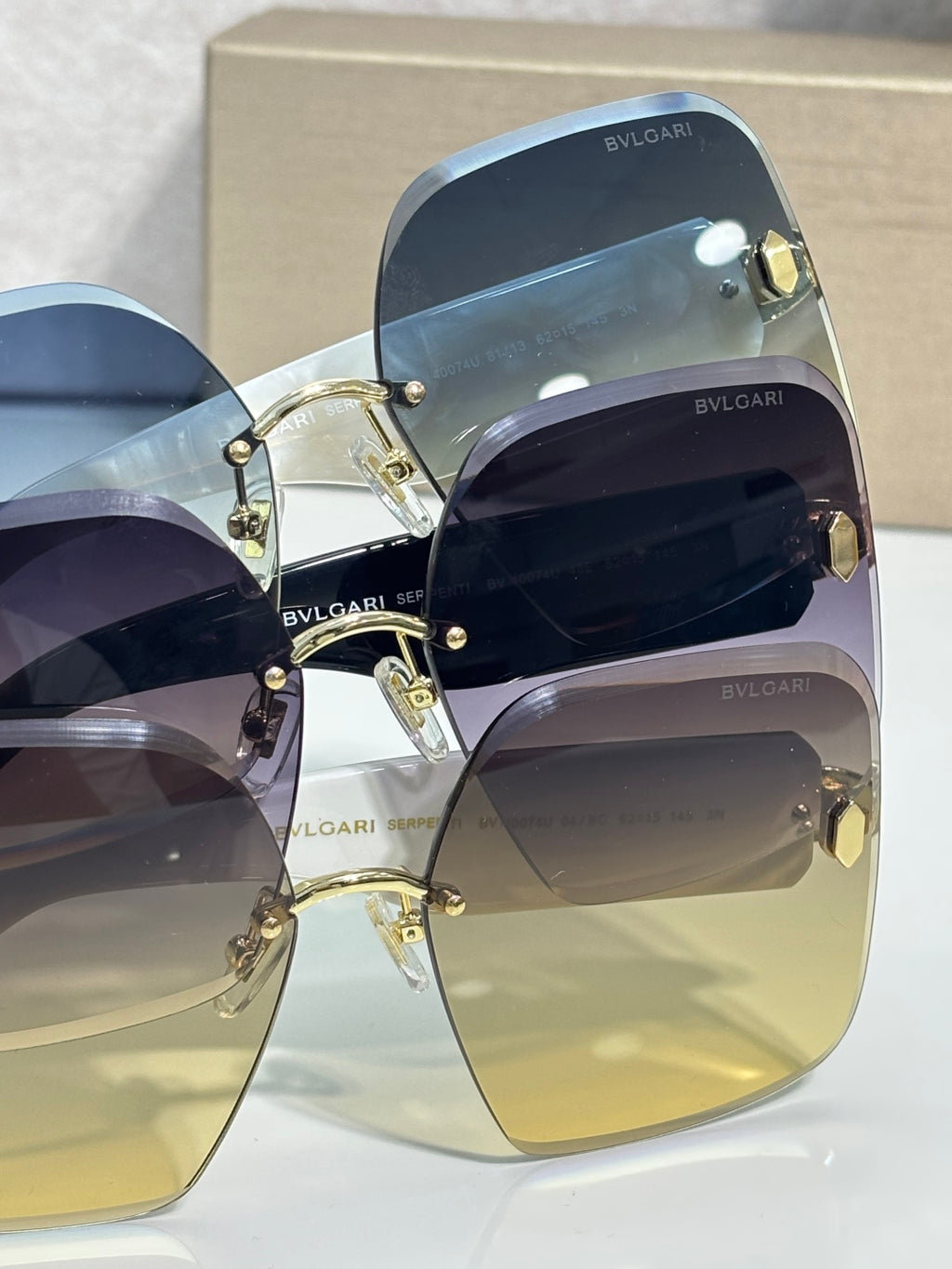 Bvlgari blue gradient sunglasses close-up with gold-tone settings and temple logo
