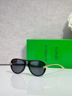 Bottega Veneta sunglasses with black frame, dark lenses, gold-tone bridge detail