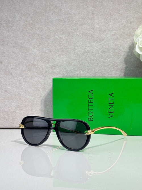 Bottega Veneta sunglasses with black frame, dark lenses, gold-tone bridge detail