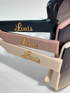 Louis Vuitton sunglasses with gold Louis logo on arms, black, pink, and white frames