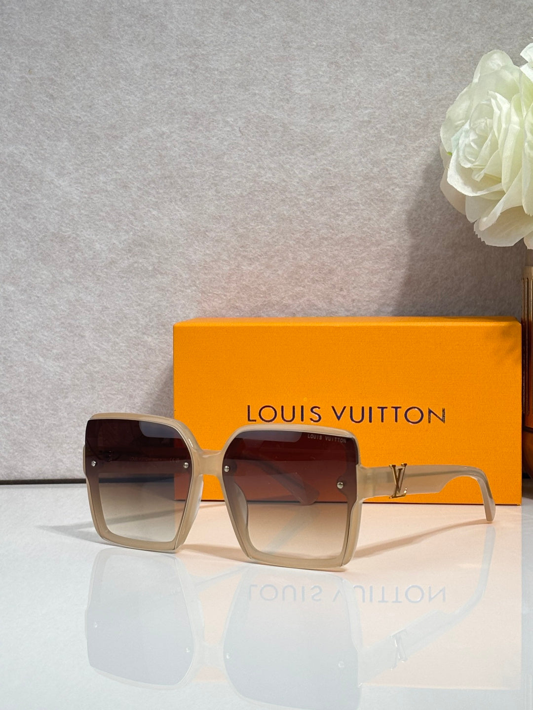 Louis Vuitton square sunglasses with dark lenses and tan frame, logo on arms