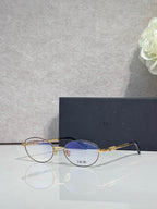 Round eyeglasses with blue-tinted lenses, gold metal frame and temples