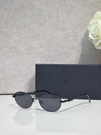 Round eyeglasses with blue monogram-pattern lenses and gold metal frame