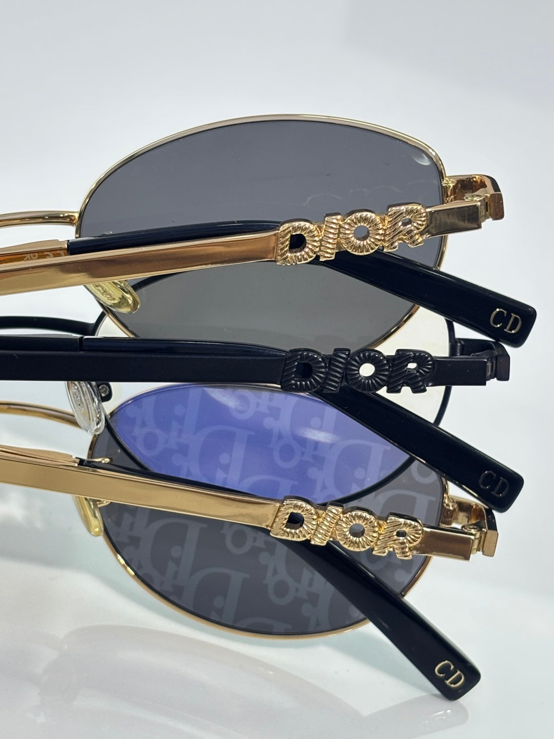 Gold sunglasses frames with ornate hinge detail, dark lenses, and DIOR logos
