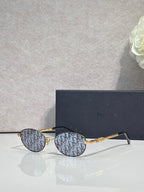 Round eyeglasses with blue monogram-pattern lenses and gold metal frame