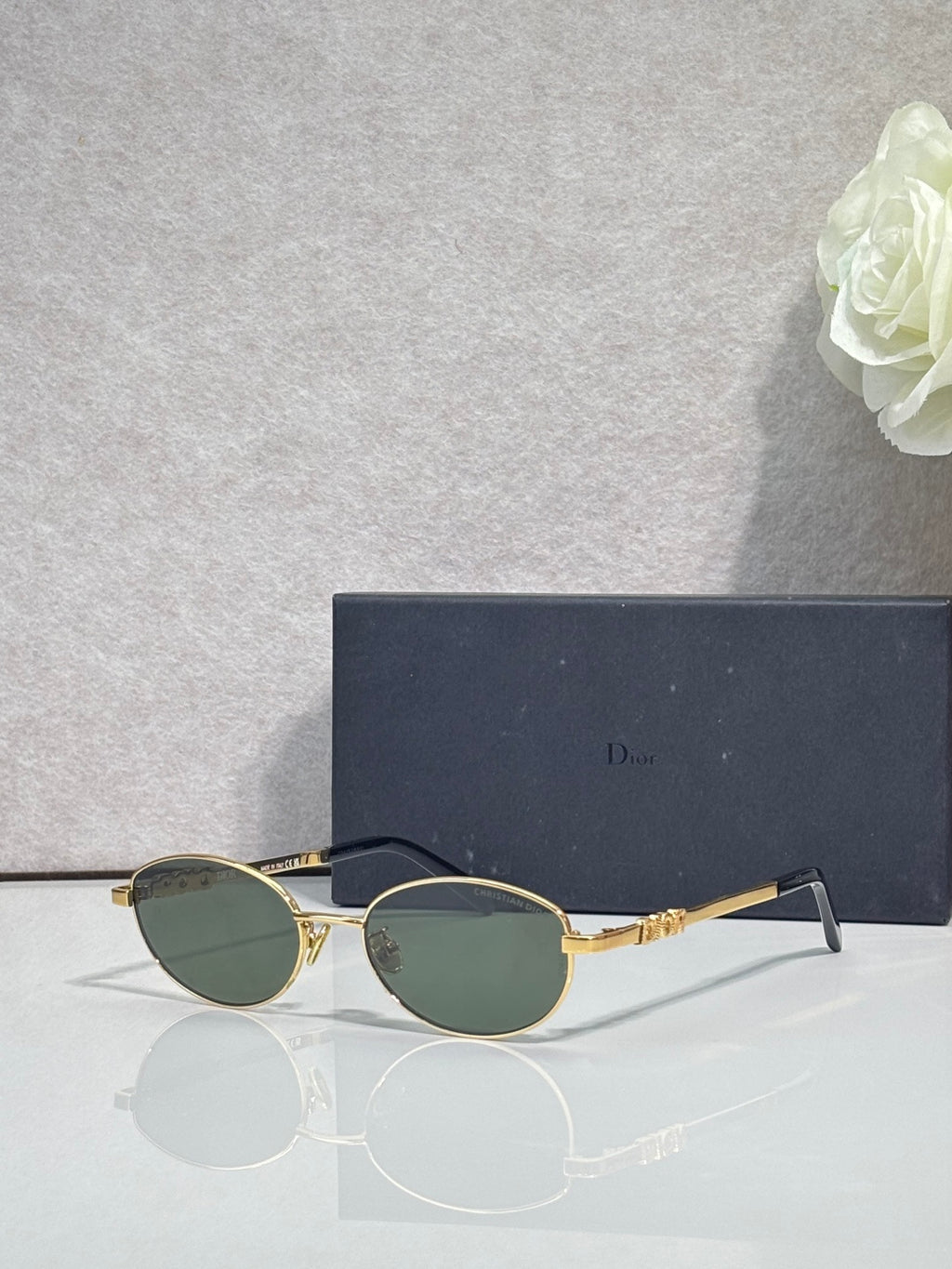 Round sunglasses with green-tinted lenses and gold metal frame
