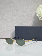 Round sunglasses with green-tinted lenses and gold metal frame