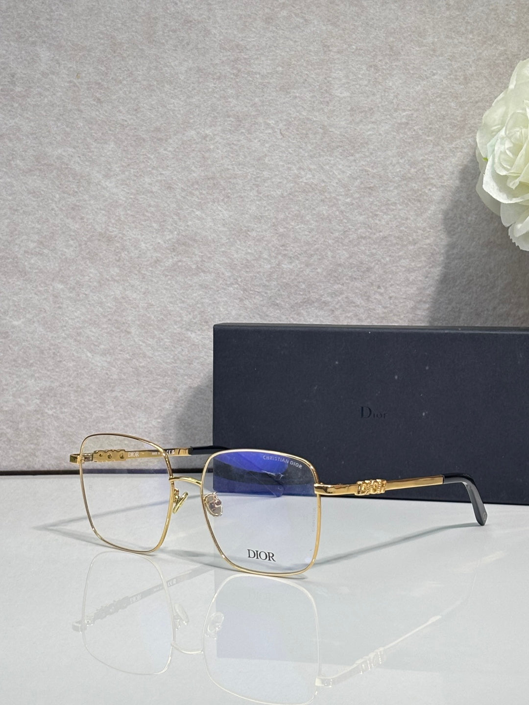 Dior eyeglasses with clear lenses, gold bridge detail, angled side view