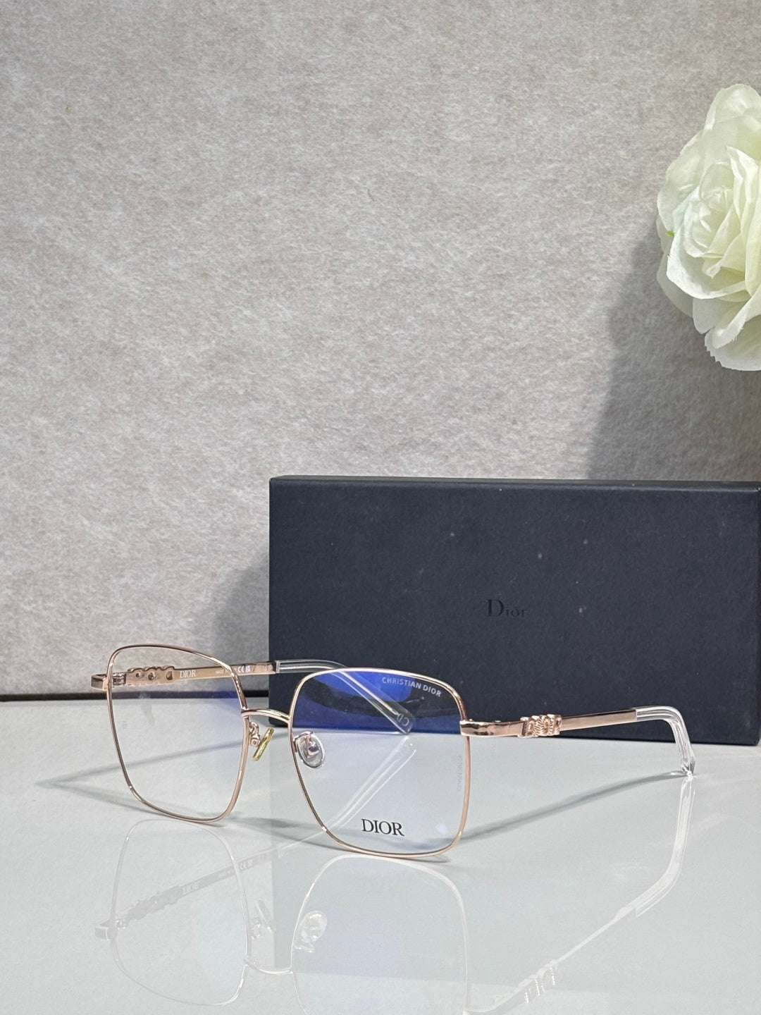 Dior eyeglasses with clear frame, gold temples, and blue-tinted lenses