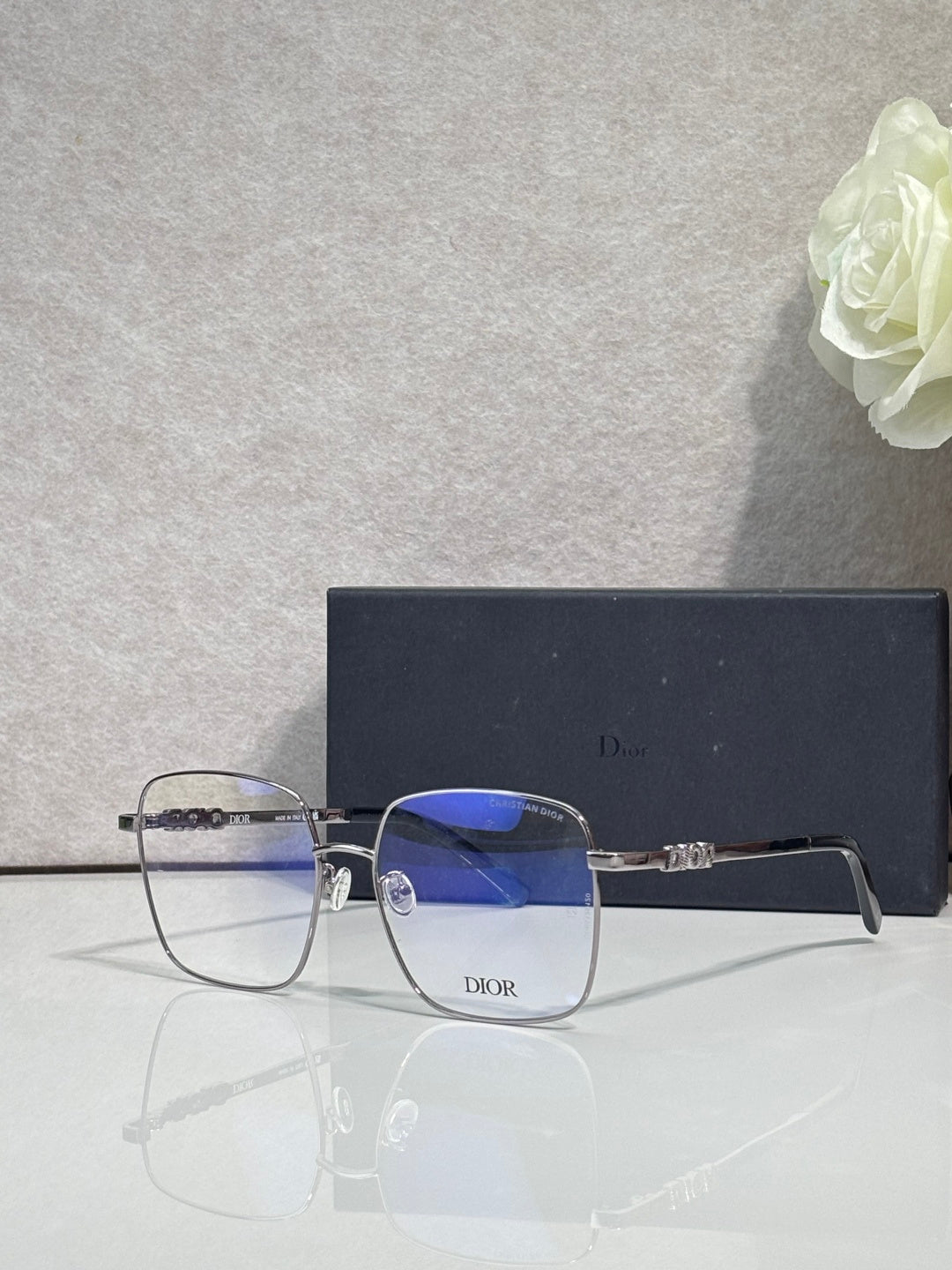 Dior eyeglasses with clear blue-tinted lenses and gold-tone metal frames