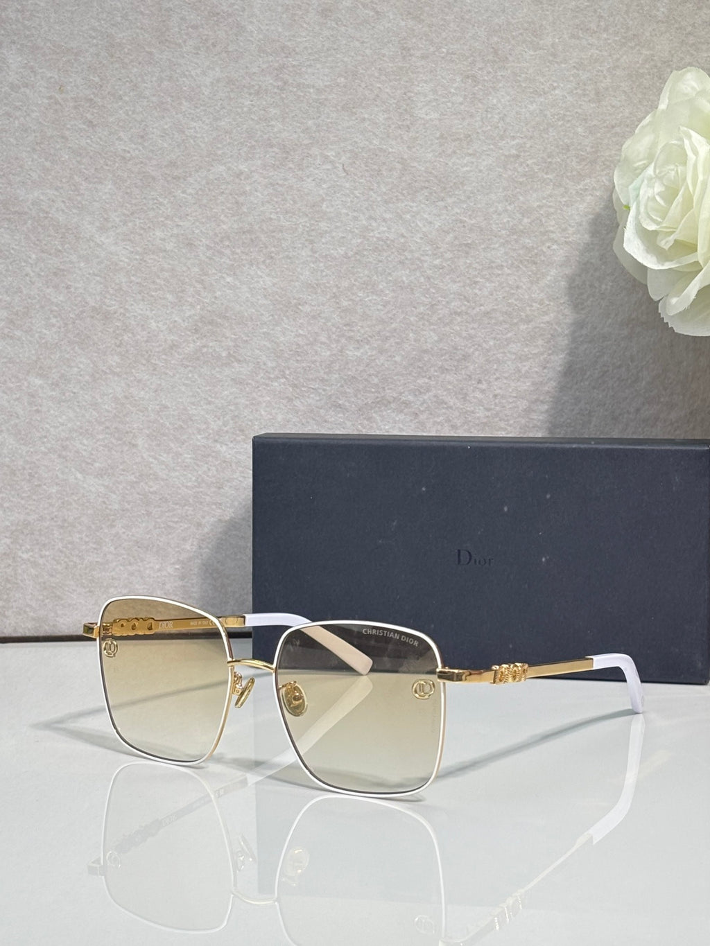 Dior eyeglasses with clear lenses, gold temples, and white front detail