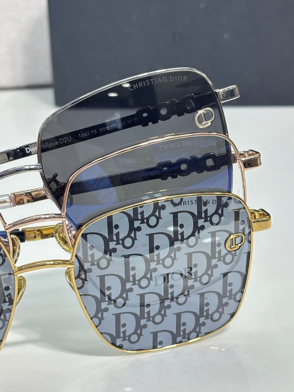 Dior eyeglasses close-up with navy Dior monogram lenses and gold-tone trim