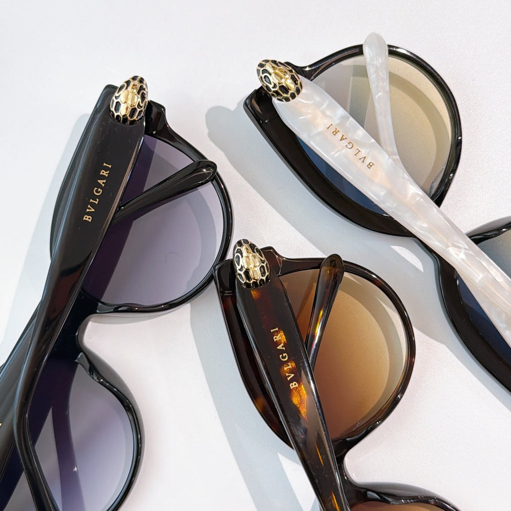 Sunglasses assortment with purple, amber, and black frames on a display