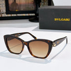 Tortoiseshell cat-eye sunglasses with brown lenses and gold logo detail at the temple hinge