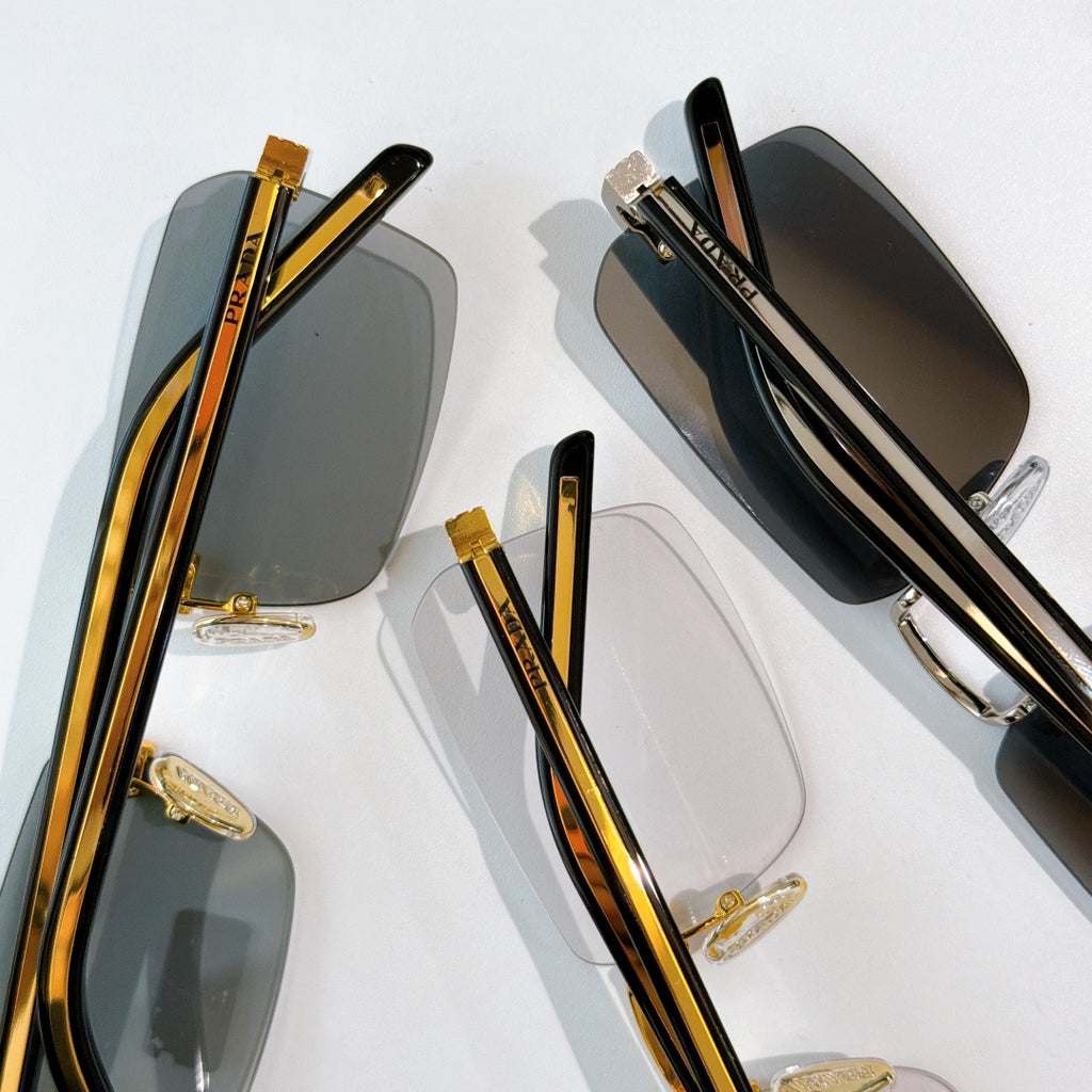 Prada eyeglasses close-up with dark lenses, gold metal accents, and tortoiseshell temples