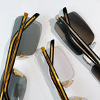 Prada eyeglasses close-up with dark lenses, gold metal accents, and tortoiseshell temples