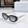 Black Dior sunglasses with round lenses and clear arms, white floral bow detail.