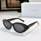 Black Dior sunglasses with oval lenses, dark tint, and small side logo on arm.