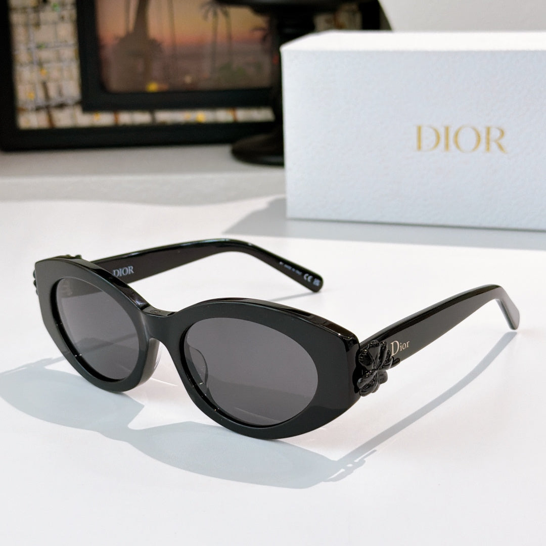 Black Dior sunglasses with oval lenses, dark tint, and small side logo on arm.