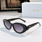 Black Dior sunglasses with oval lenses and purple tint, white floral detail on temple.