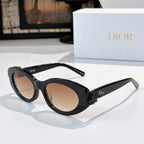 Black Dior sunglasses with oval lenses and white floral bow detail on the arm.