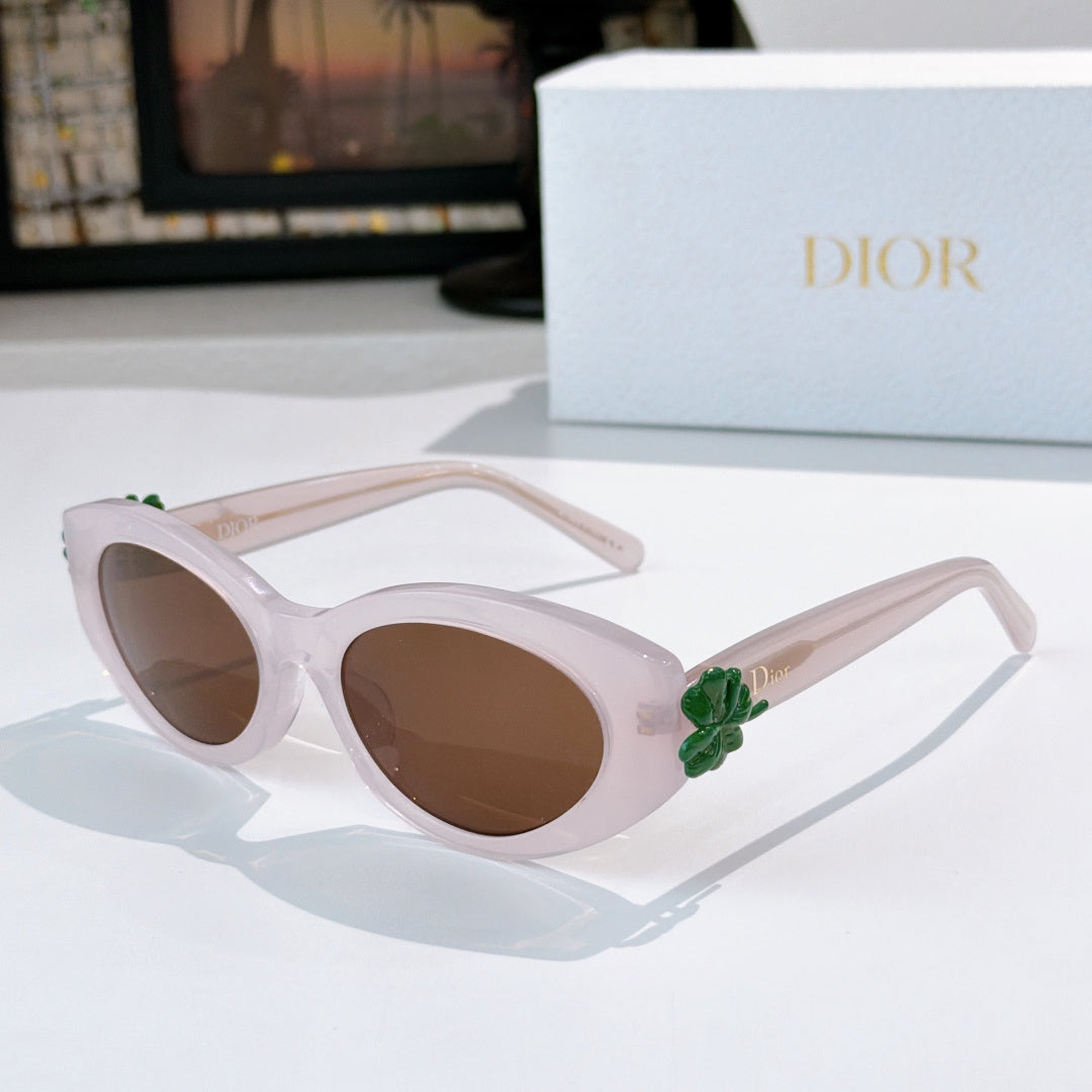 Light pink Dior sunglasses with brown lenses and green flower detail on arm.