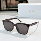 Cat-eye sunglasses with dark lenses and black acetate frame, gold stud details