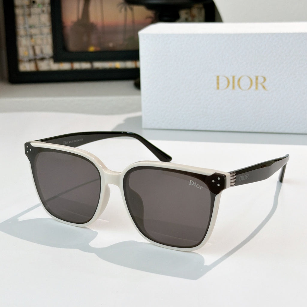 Cat-eye sunglasses with dark lenses and light frame, gold stud accents on hinges