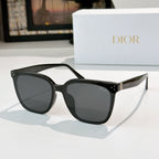Cat-eye sunglasses with dark lenses and glossy black frame, gold logo details