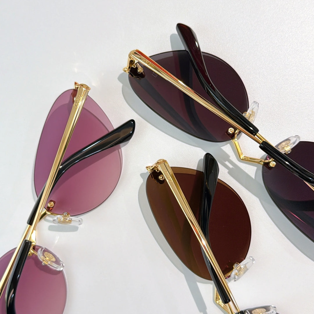 Gold-tone sunglasses with purple-tinted lenses and black temple tips, oval cat-eye pair