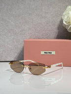 MiuMiu glasses with brown-tinted lenses and thin metal frame, gold accents on temples