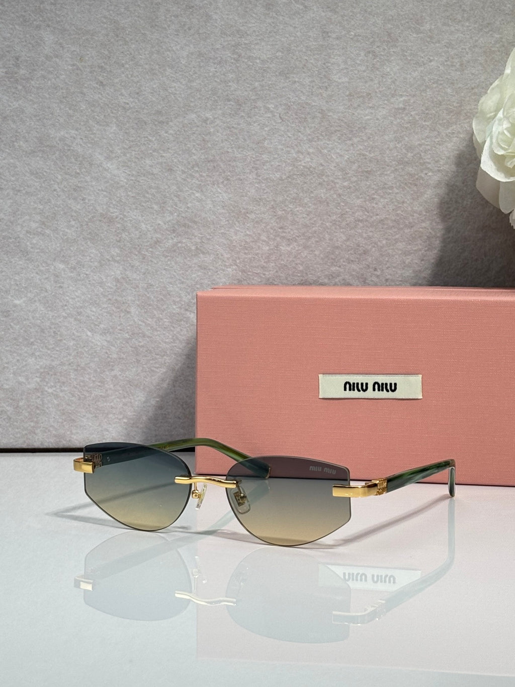 MiuMiu glasses with gradient tinted lenses and slim metal frame with gold temple tips