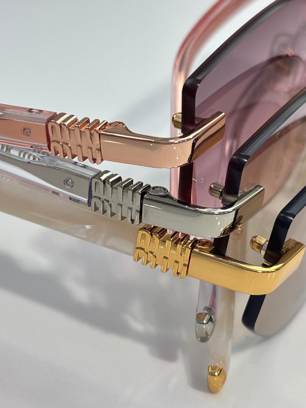 MiuMiu glasses close-up of hinges and gold metal details with clear lens edge