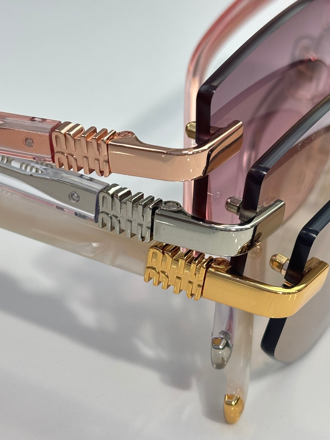 MiuMiu glasses close-up of hinges and gold metal details with clear lens edge