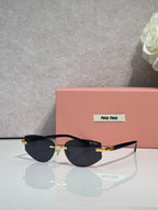 MiuMiu glasses with dark lenses and thin metal frame, gold accents at the temple