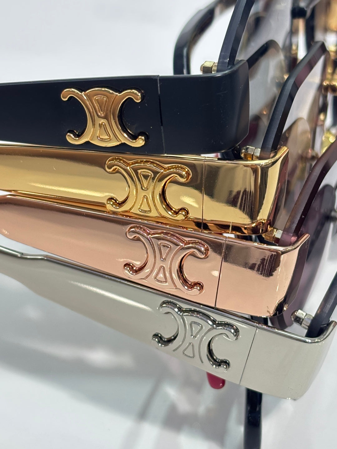 Celine sunglasses close-up: gold, silver, and dark temple with decorative logo