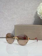 Gold-rim round sunglasses with dark brown gradient lenses and thin metal arms.