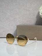 Gold-rim round sunglasses with amber tinted lenses and curved metal temples.