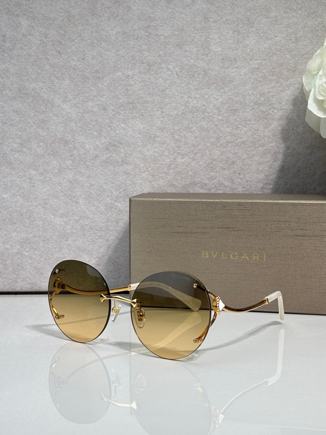 Gold-rim round sunglasses with amber tinted lenses and curved metal temples.
