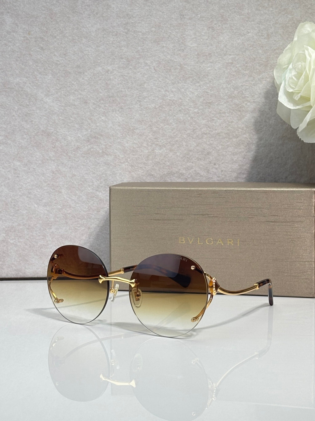 Gold-rim round sunglasses with dark brown tinted lenses and slim metal temples.