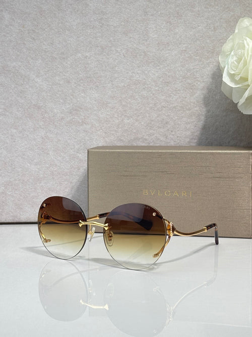 Gold-rim round sunglasses with dark brown tinted lenses and slim metal temples.