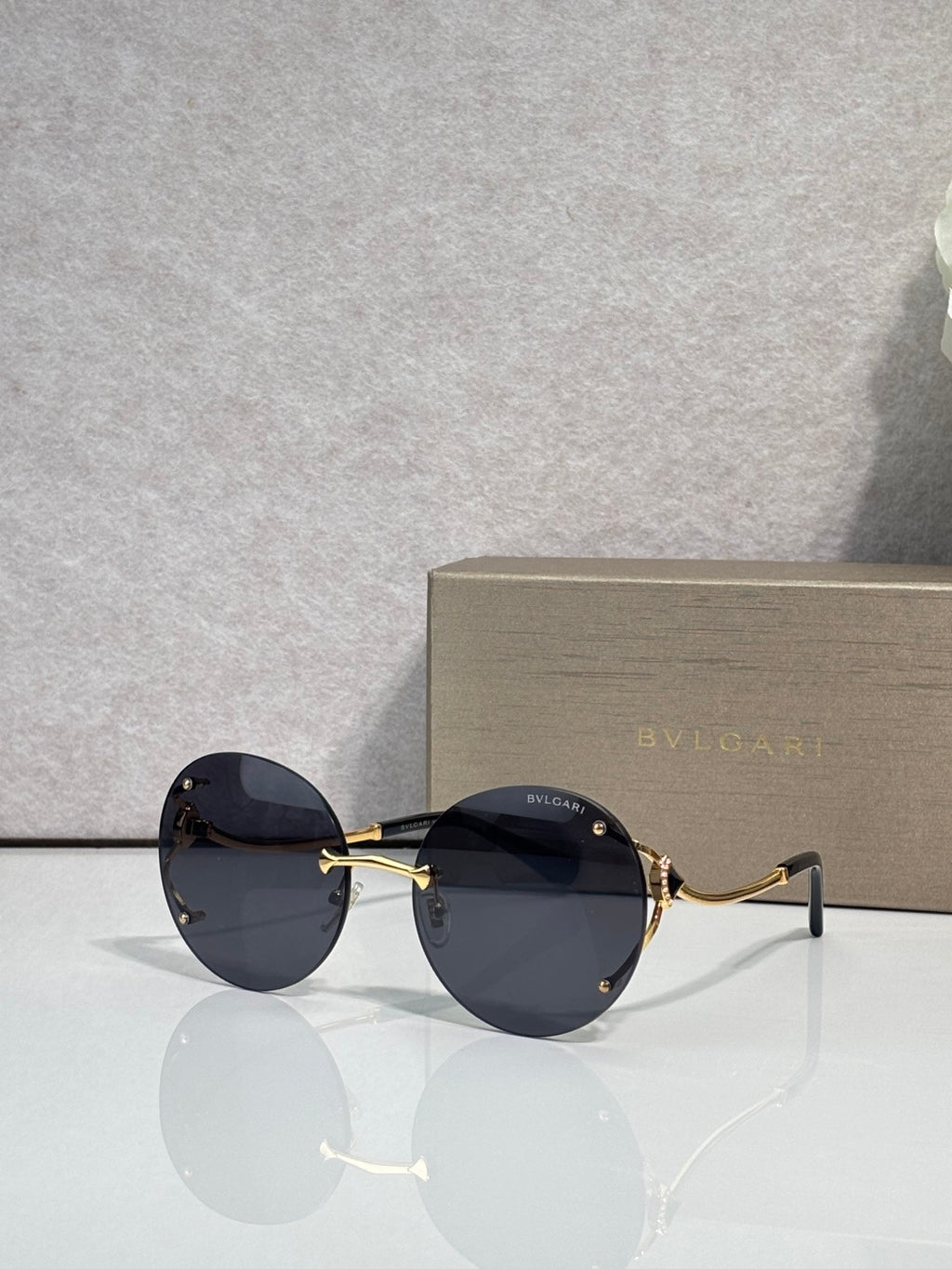 Gold-rim round sunglasses with dark navy tinted lenses and slim metal temples.